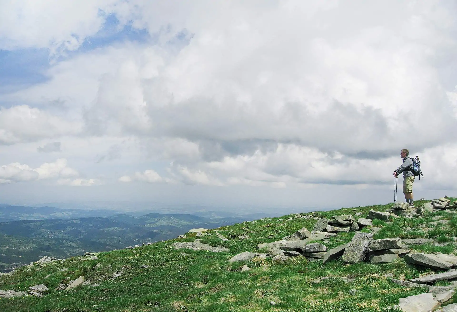 Man standing on a hill looking over Babia Góra National Park, Poland